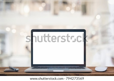 Computer notebook and mouse with a coffee shop behind the scenes Blur coffee shop, Blur restaurant sun flare effect photo.