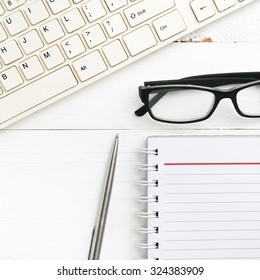 computer and notepad over white table