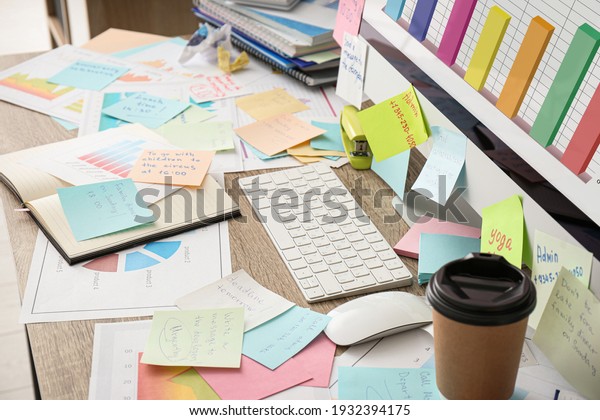 Computer, notes and office stationery in mess on\
desk. Overwhelmed with\
work