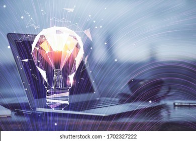 Computer on desktop in office with bulb icon hologram. Multi exposure. Concept of idea.