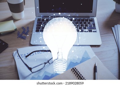Computer on desktop in office with bulb icon hologram. Double exposure. Concept of idea. - Shutterstock ID 2189028059
