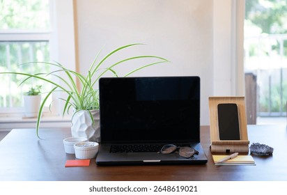 Computer on kitchen table for remote work, research, writing, designing and going on the internet. Mobile device is on stand nearby.
