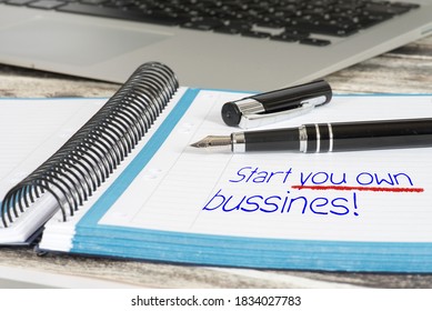 A Computer On An Office Table And A Notebook With The Word Start You Own Bussines