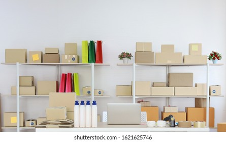 Computer On Wooden Working Table With Package Product Box Delivery Background In Room In Apartment Indoor. Startup Small Business SME Concept