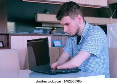 Computer online job. Disabled man freelancer with amputated two stump hands in cafe typing works on laptop Problem of adaptation to life people disabilities. Independent handicapped invalid young guy.