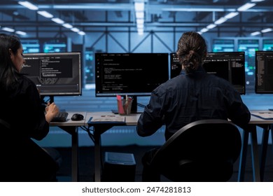 Computer operators in data center running system diagnostic tests to do repairments. IT specialists at PC desk in server room deploying error checking utilities to fix network issues - Powered by Shutterstock