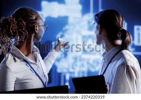 Computer operators thinking of ways to use AI cognitive computing to extract usable information from complex data. Server room employees implement artificial intelligence to process massive datasets
