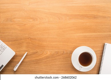 Computer, pen, notepad and tea cup on a table 