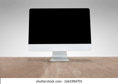 A computer placed on a desk, a gray wall background, a blank screen to insert various media messages
