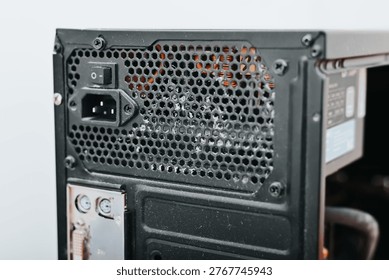 A computer power supply unit is shown from the back, highlighting its various connections and ventilation grill.