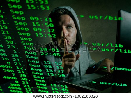 computer programmer man in hoodie hacking system entering code typing on laptop hacking and decoding system data illegal access breaking password on cyber attack and security breach