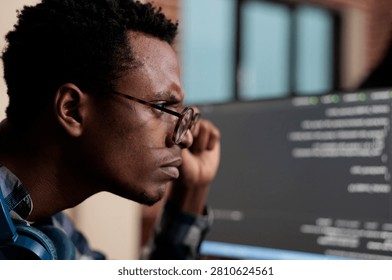 Computer programmer puzzled by nonfunctional security algorithm and company corrupted database, confused tech engineer sitting doubtful at computer trying to solve network processing errors.