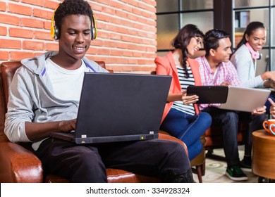 Computer Programmer In Start-up Company Coding, Co-workers In The Background