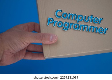 Computer Programmer word with cardboard box. Brown folded card box.