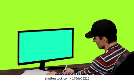 Computer programmer writing notes in front of mockup on green screen, Chroma key