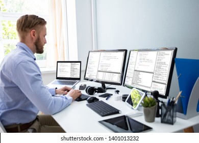 Computer Programmer Writing Program Code On Computer In Office 