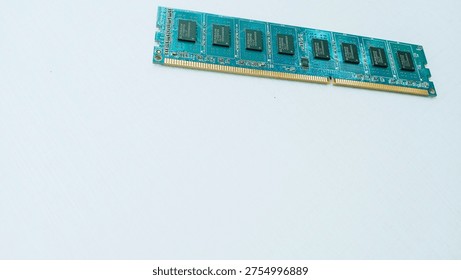 Computer RAM Module on White Surface, The image features a computer RAM (Random Access Memory)Module. placed on a flat white surface .The circuit board is greenish-blue, showcasing multiple black memory chips aligned along its length.The golden connector pins at the bottom edge are visible, allowing the RAM to interface with a Computer motherboard.