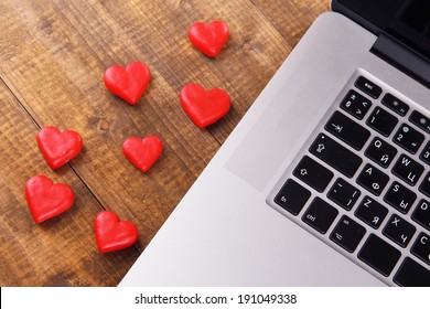Computer with red hearts on table close up