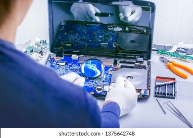 Computer Repair. Tech fixes motherboard in service center.