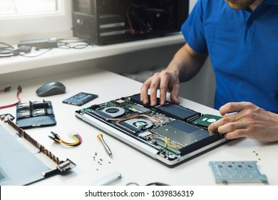 Computer Repairman Installing New Hard Disk Drive In Laptop