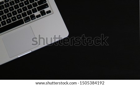 Computer resting on black table. Space for your text