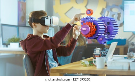 In A Computer Science Class Boy Wearing Virtual Reality Headset Works In Interactive 3D Environment. Mechanical Modeling Project Of Connecting Gears With Augmented Reality Software.