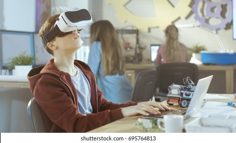 In a Computer Science Class Boy Wearing Virtual Reality Headset Works on a Programing Project.
