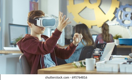 In a Computer Science Class Boy Wearing Virtual Reality Headset Works on a Programing Project.
