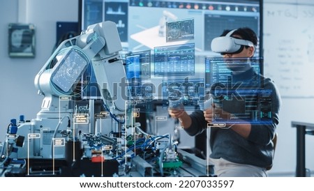Computer Science Engineer in Virtual Reality Headset Using Controllers and Operating Robot Arm Under his Control. VFX Augmented Reality Interfaces and Icons Demonstrate Innovative Technologies.