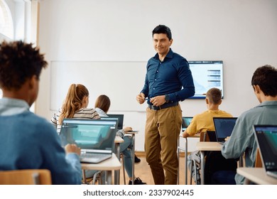 Computer science teacher and high school students having a class in the classroom. - Powered by Shutterstock