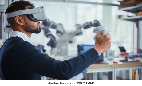 Computer Science Worker in Virtual Reality Headset Holding Controllers and Moving Bionic Claw. Man Developing Program for Motion of Robotic Arm. Innovative Automation Technologies Concept.