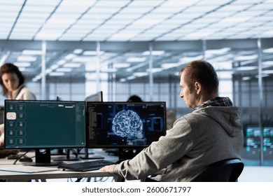 Computer scientist in data center coding AI LLM chatbo answering user prompts using predictive technology. Server room employee building large language model program using artificial intelligence - Powered by Shutterstock - Get 15% off with code: PIKWIZARD15