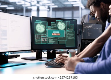 Computer scientist in data center getting access denied notification on PC screen, trying to access server files after they were locked by hacker using ransomware, requesting help from IT expert