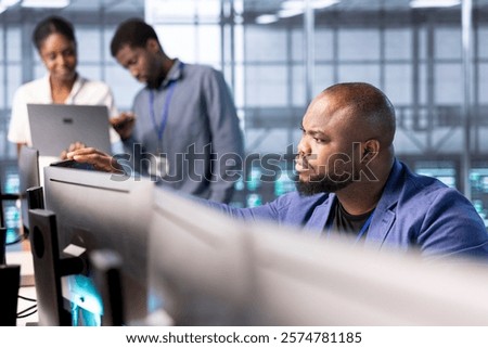 Computer scientist in data center workspace using diagnostic tools and system monitoring software to identify root cause of errors. IT specialist working in server room, mending equipment