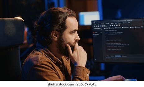 Computer scientist drinking cup of coffee while developing code on PC using java programming languages. IT admin brainstorming ways of fixing database errors, enjoying hot beverage, camera A