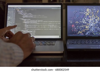 Computer scientist pointing at code screen with algorithmic data 