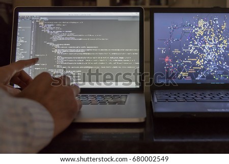 Computer scientist pointing at code screen with algorithmic data 