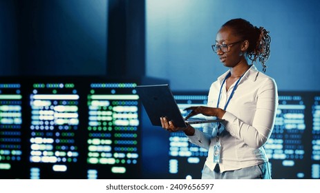 Computer scientist programming in server farm housing advanced equipment storing massive datasets. Developer running code on laptop to fix data center racks doing complex computational operations - Powered by Shutterstock