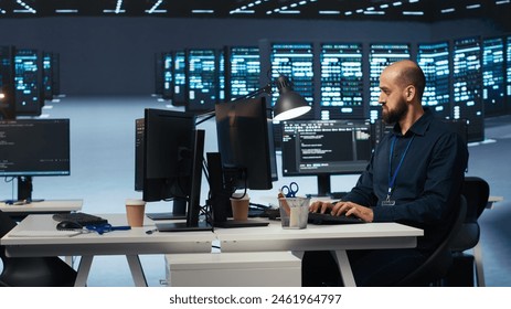 Computer scientist in server farm coding, ensuring data remains shielded from threats. IT programmer safeguarding supercomputers against unauthorized access, securing system from virus attacks