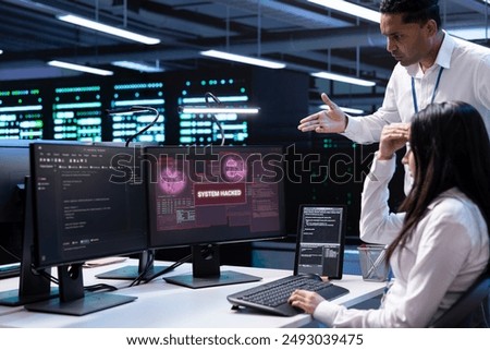 Computer scientist in server hub asking coworker for help, trying to protect equipment from hacker. IT specialist in data center facility requesting assistance to fix security breach alert