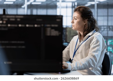 Computer scientist in server room implementing power management solutions to reduce energy consumption. Woman using PC, integrating new technologies and systems in data center