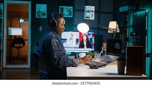 Computer scientist updating artificial intelligence neural networks, writing binary code scripts. Remote worker in apartment office uses digital device programming to upgrade AI, camera B