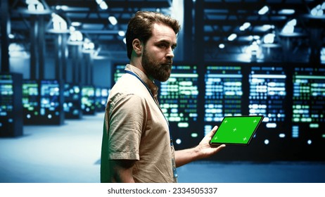 Computer scientist using green screen tablet to verify data center configuration settings. Repairman looking at monitoring software to troubleshoot defective server mainframes root cause