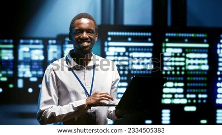 Computer scientist using tablet to analyze server cabinets providing computing resources and storage, enabling artificial intelligence to process massive datasets for training and machine learning