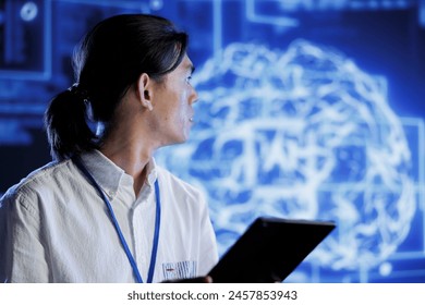 Computer scientist using tablet to maintenance artificial intelligence neural networks simulating human thought processes in computerized model. Tech support doing checkup on AI systems
