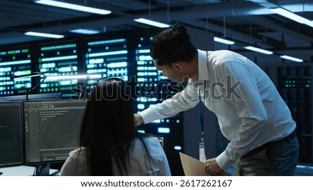 Computer scientists in data center managing and maintaining databases, ensuring data integrity and security. IT staff members updating server room systems using, camera A