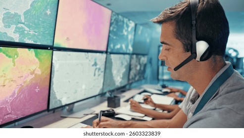 Computer, screen and man with headset in control room for storm tracking, satellite forecast or writing weather pattern. Meteorology, person and radar display for atmosphere monitor or cyclone data