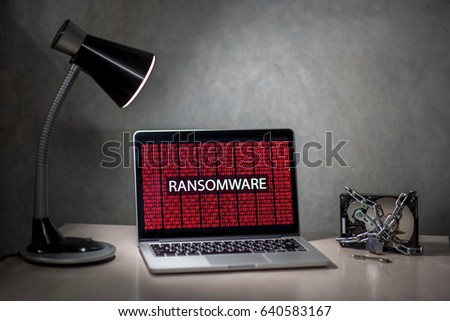Computer screen with ransomware attack alert in red digital binary background with hard disk drive lock. Cyber attack concept