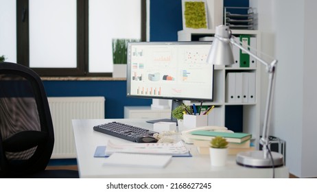 Computer Screen With Sales Statistics On Diagram At Desk In Empty Startup Office. No People In Professional Workplace With Monitor Showing Financial Data Charts For Business Growth.