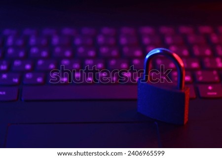 Computer security concept with a closed padlock on the keyboard. Padlock on top of a laptop keyboard. Selective focus Toned image